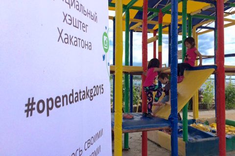 Children playing on a colorful playground structure at an event in Bishkek, Kyrgyzstan.