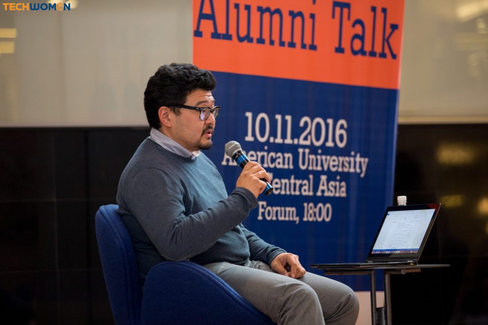 Man speaking at a microphone during an Alumni Talk event at American University Central Asia, Bishkek, Kyrgyzstan.