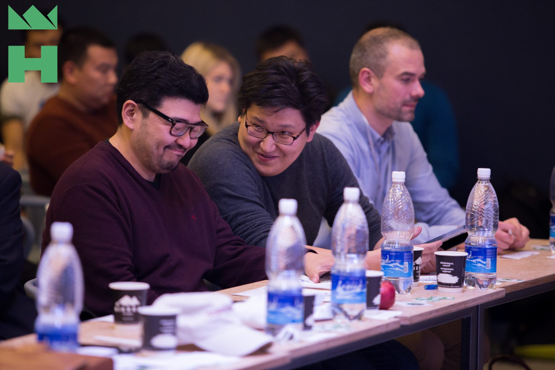 Participants in a workshop or conference setting, engaged in discussion.