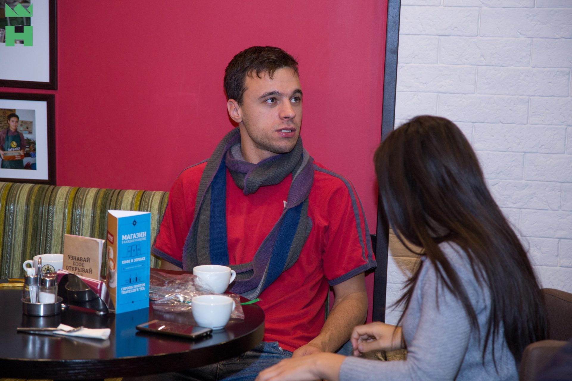 A group of people in a meeting room with documents, snacks, and drinks on the table.