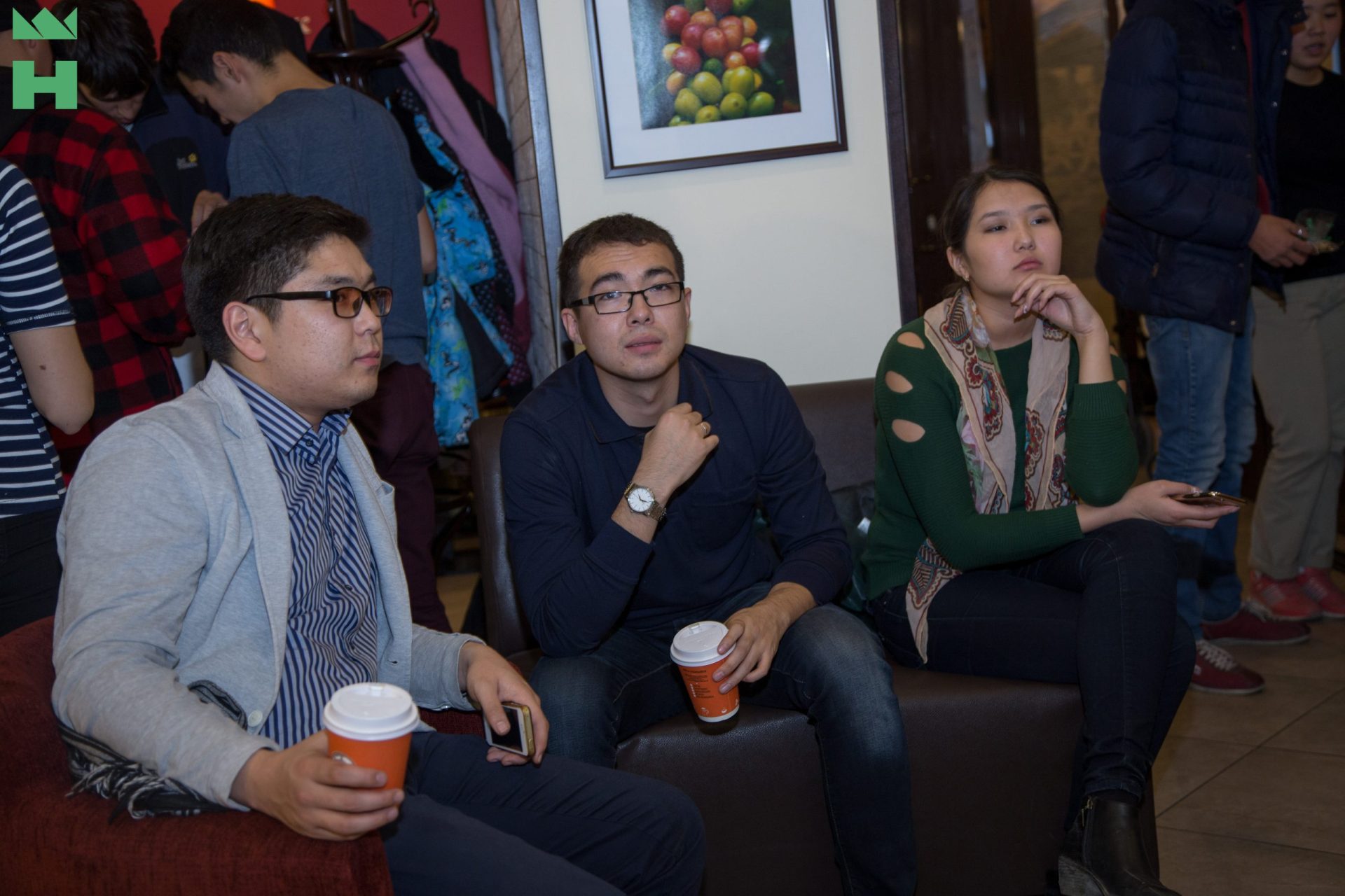 Participants in a digital transformation workshop in Bishkek, Kyrgyzstan, sitting on a couch with coffee cups.
