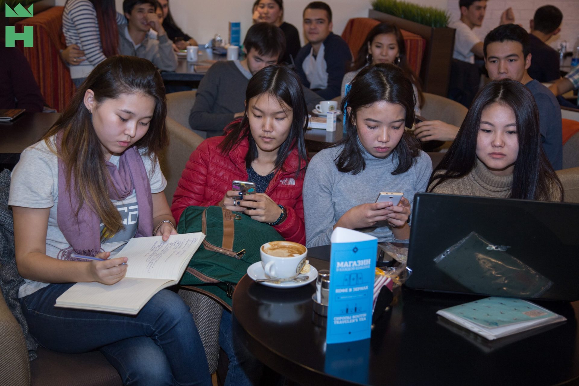 A group of people sitting in a crowded room with floral decorations.