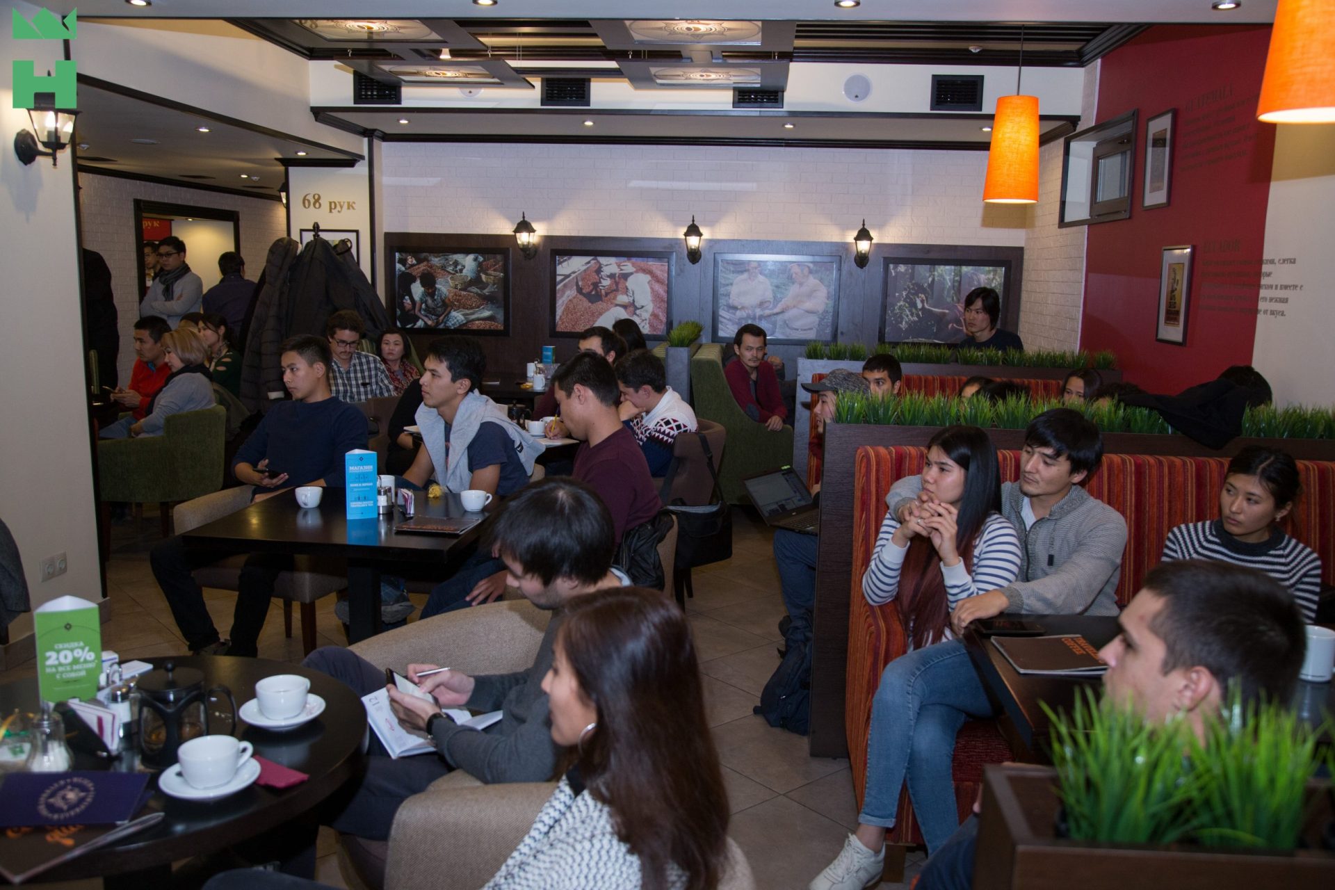 A group of people sitting in a cafe, engaged in discussions or meetings.