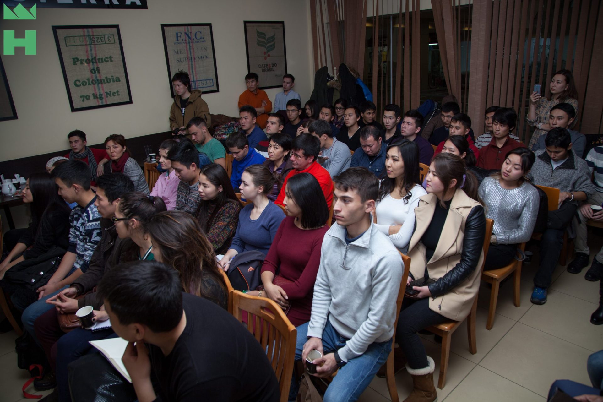 A group of people sitting in a room, possibly attending an event or workshop.