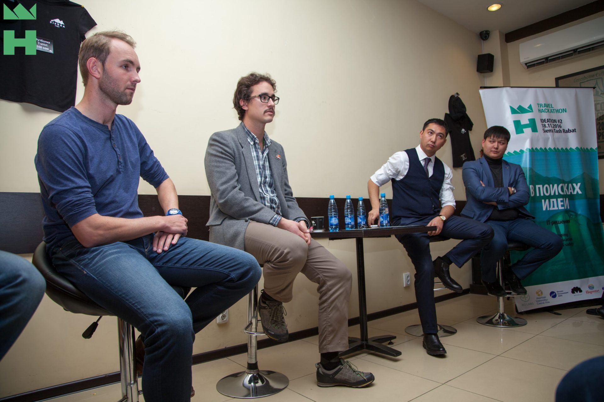 Four individuals seated at a table during a panel discussion or workshop event.