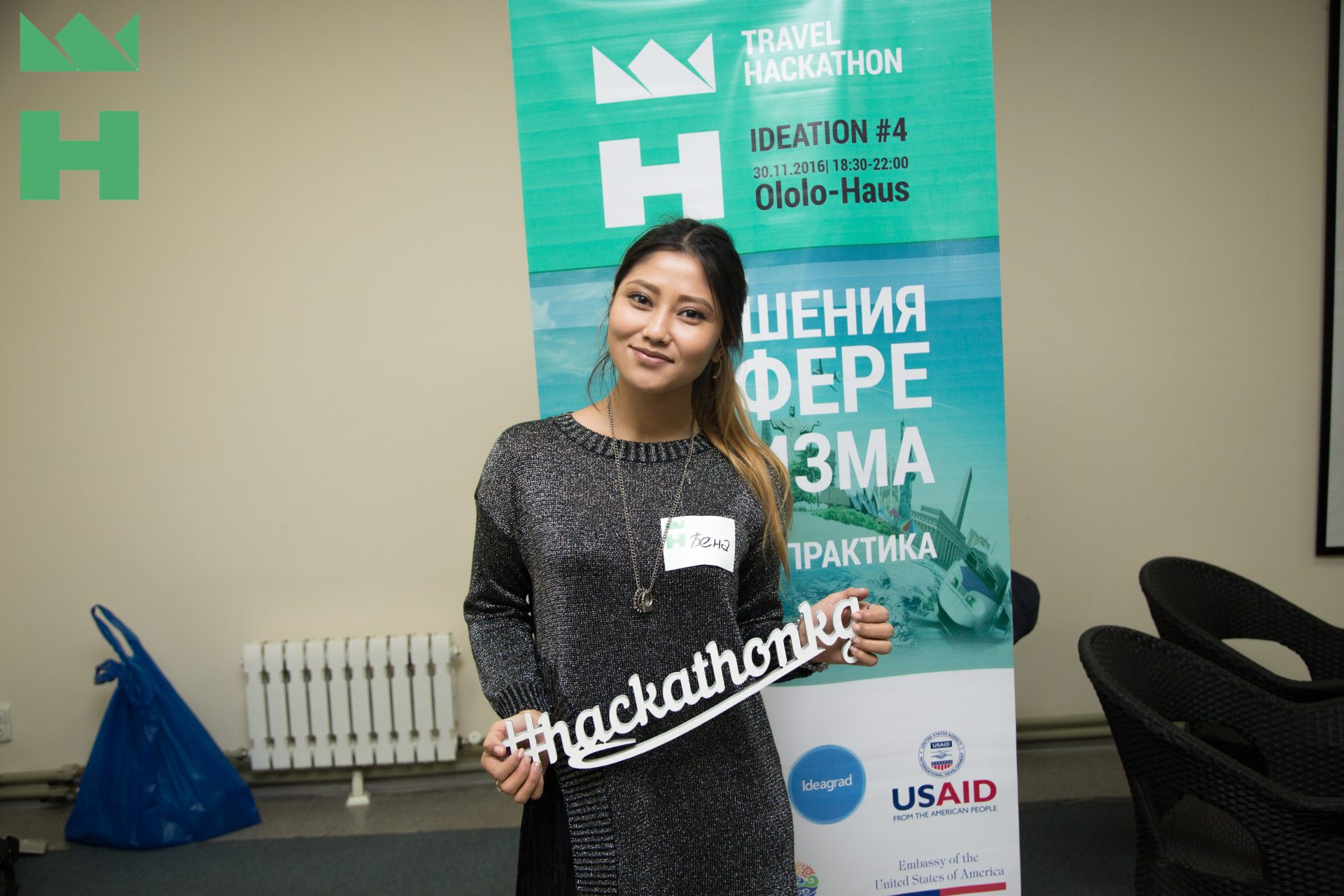 A participant holds a sign with the hashtag #hackathonkg at a Travel Hackathon event in Bishkek, Kyrgyzstan.