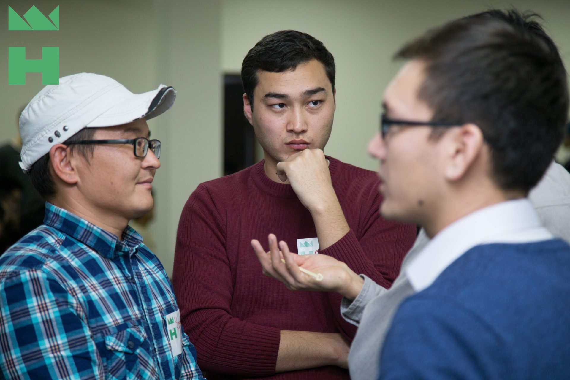 Three individuals engaged in a discussion at a KG Labs Foundation event in Bishkek, Kyrgyzstan.