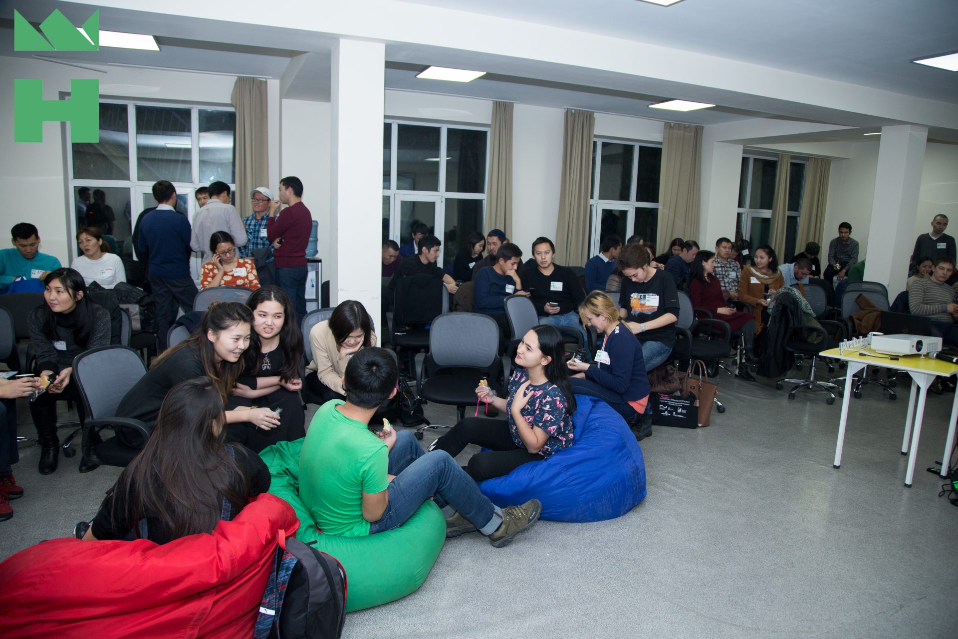 Participants in a workshop or conference at KG Labs Foundation in Bishkek, Kyrgyzstan, sitting on bean bags and chairs, engaging in discussions.