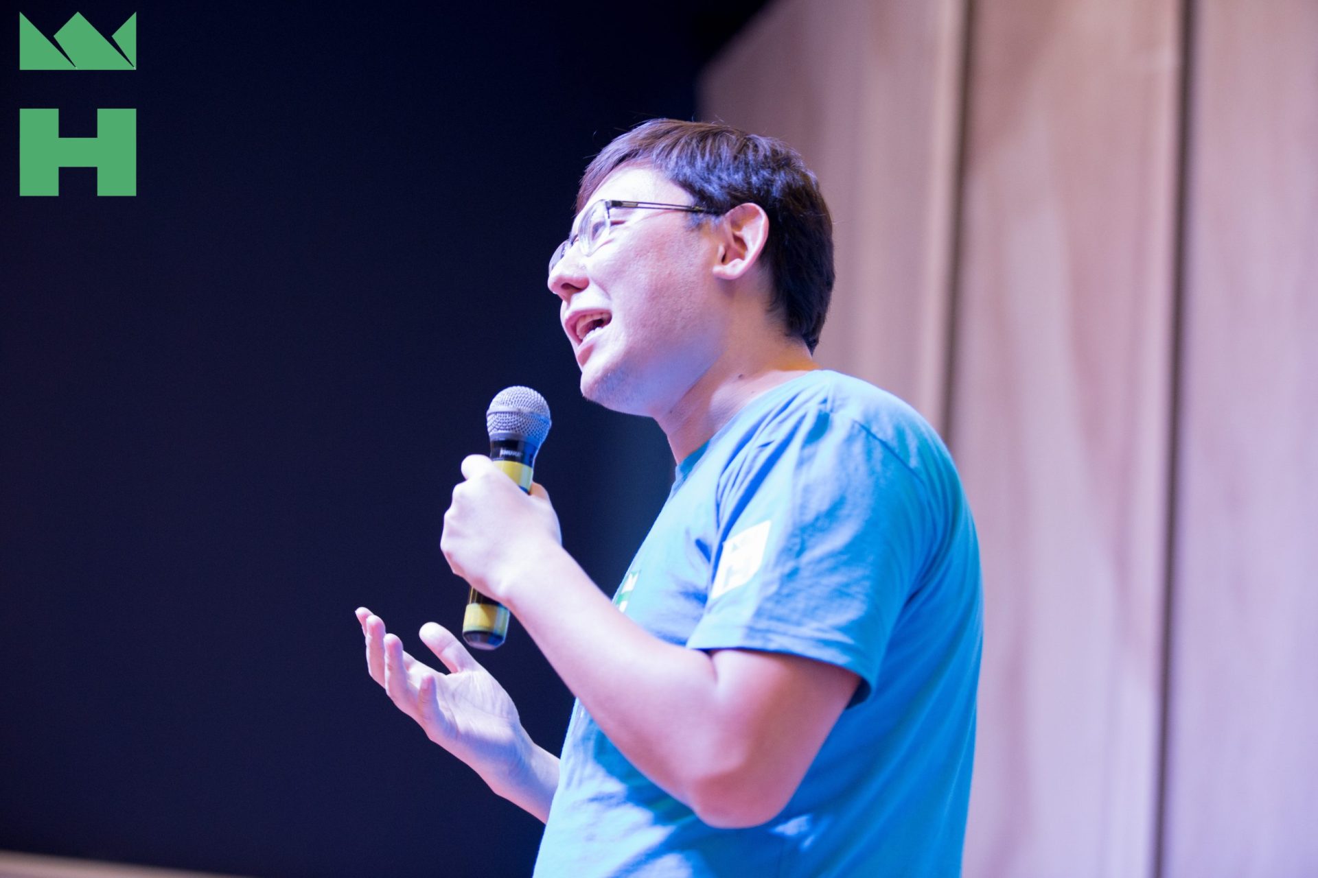 A person speaking on stage at an event in Bishkek, Kyrgyzstan.