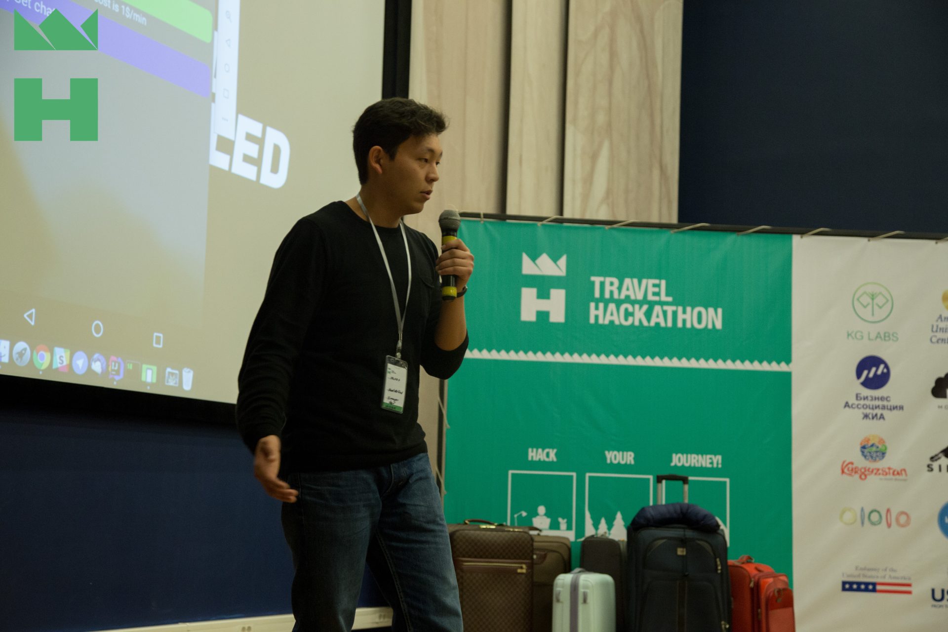 A person speaking at a Travel Hackathon event in Bishkek, Kyrgyzstan.