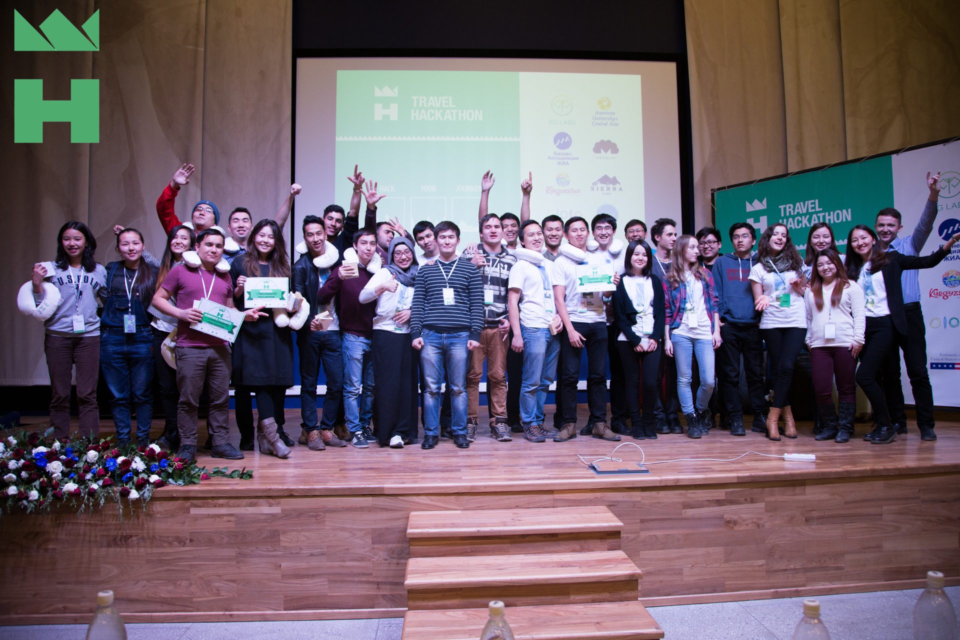 Participants at a Travel Hackathon event in Bishkek, Kyrgyzstan, celebrating their achievements.