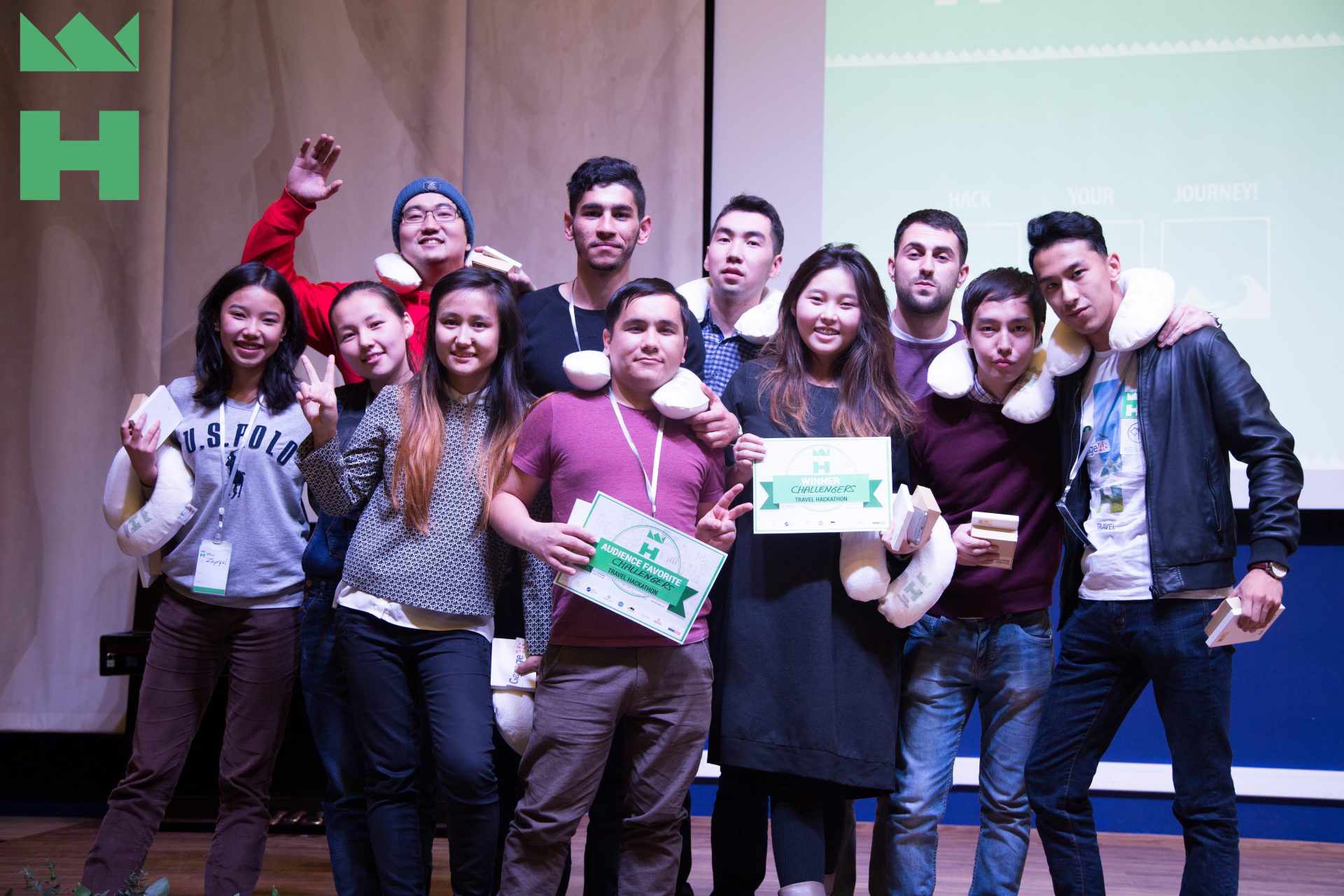 A group of people celebrating their achievement at a hackathon event in Bishkek, Kyrgyzstan.