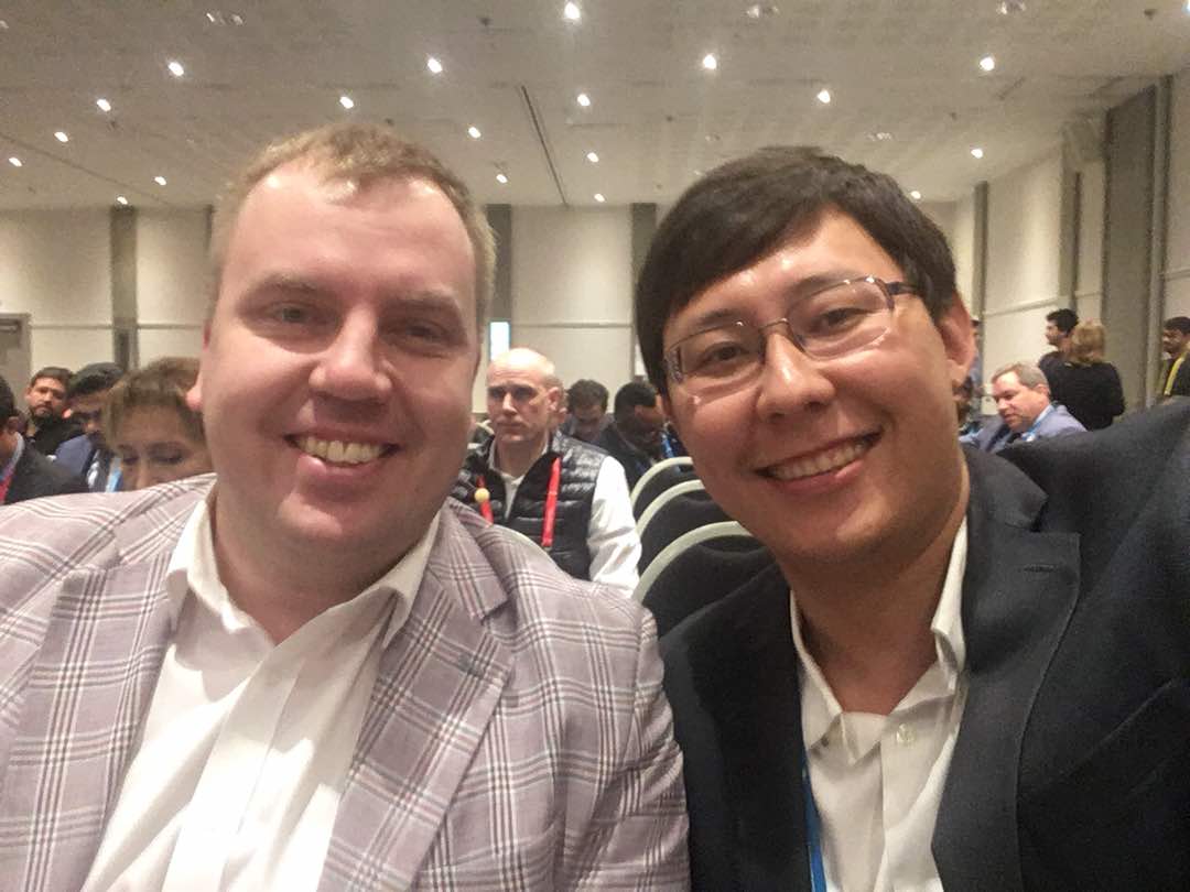 Two men smile for a selfie at an event in Bishkek, Kyrgyzstan.