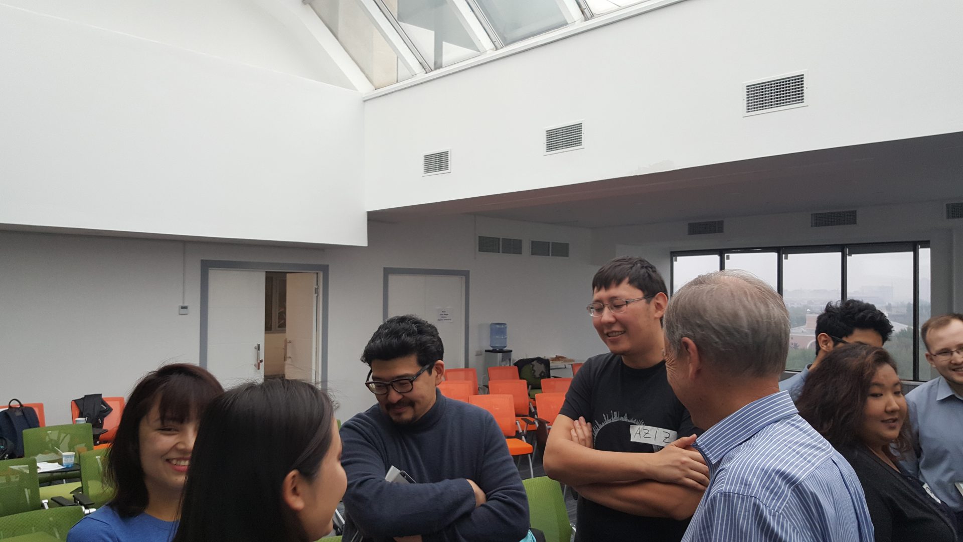 A group of people engaged in a discussion in a modern, well-lit room.