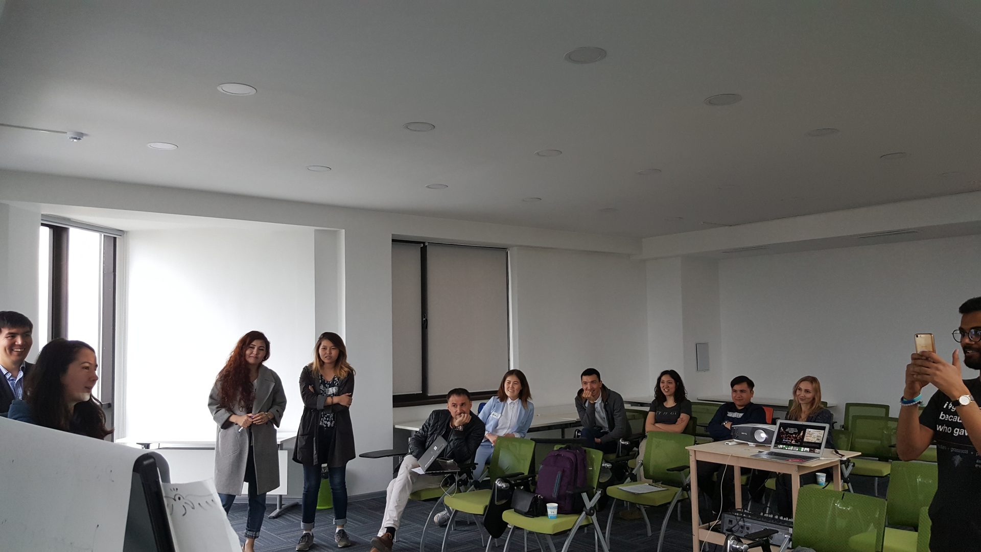 A group of people in a classroom setting, possibly attending a workshop or training session.