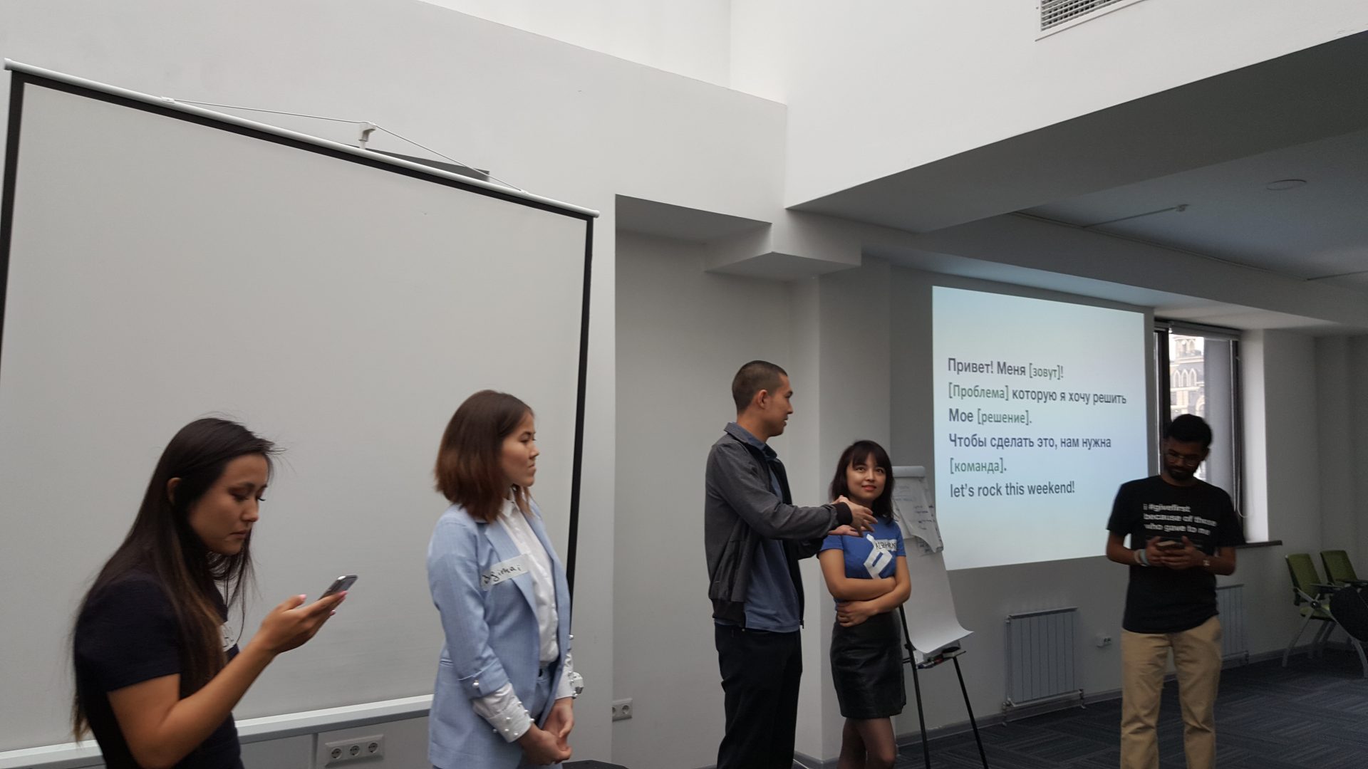 Participants in a workshop or training session in Bishkek, Kyrgyzstan, with a presentation slide in the background.