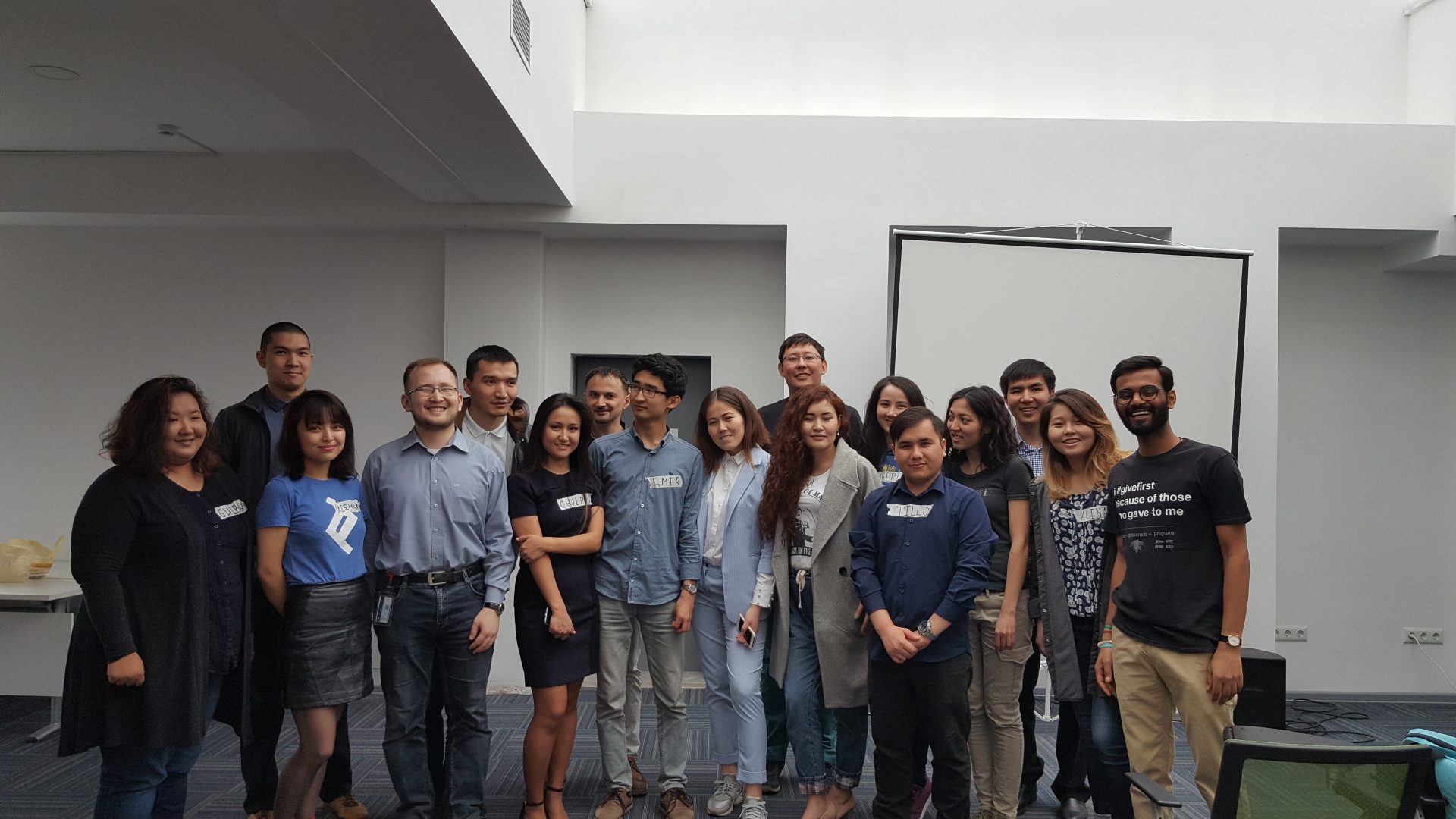 A group of people posing for a photo in a modern office setting.