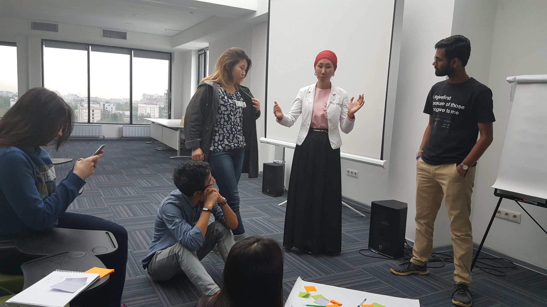 A group of people engaged in a discussion or workshop in a modern office setting.