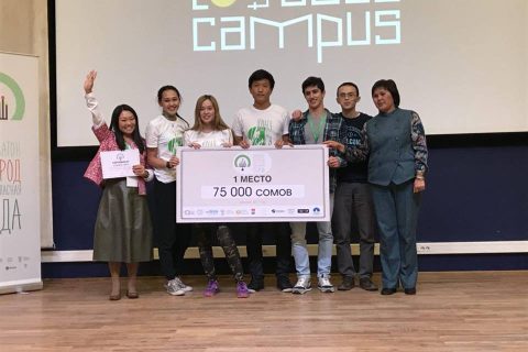 A group of people celebrates winning first place in a competition at the KG Labs Foundation event in Bishkek, Kyrgyzstan.
