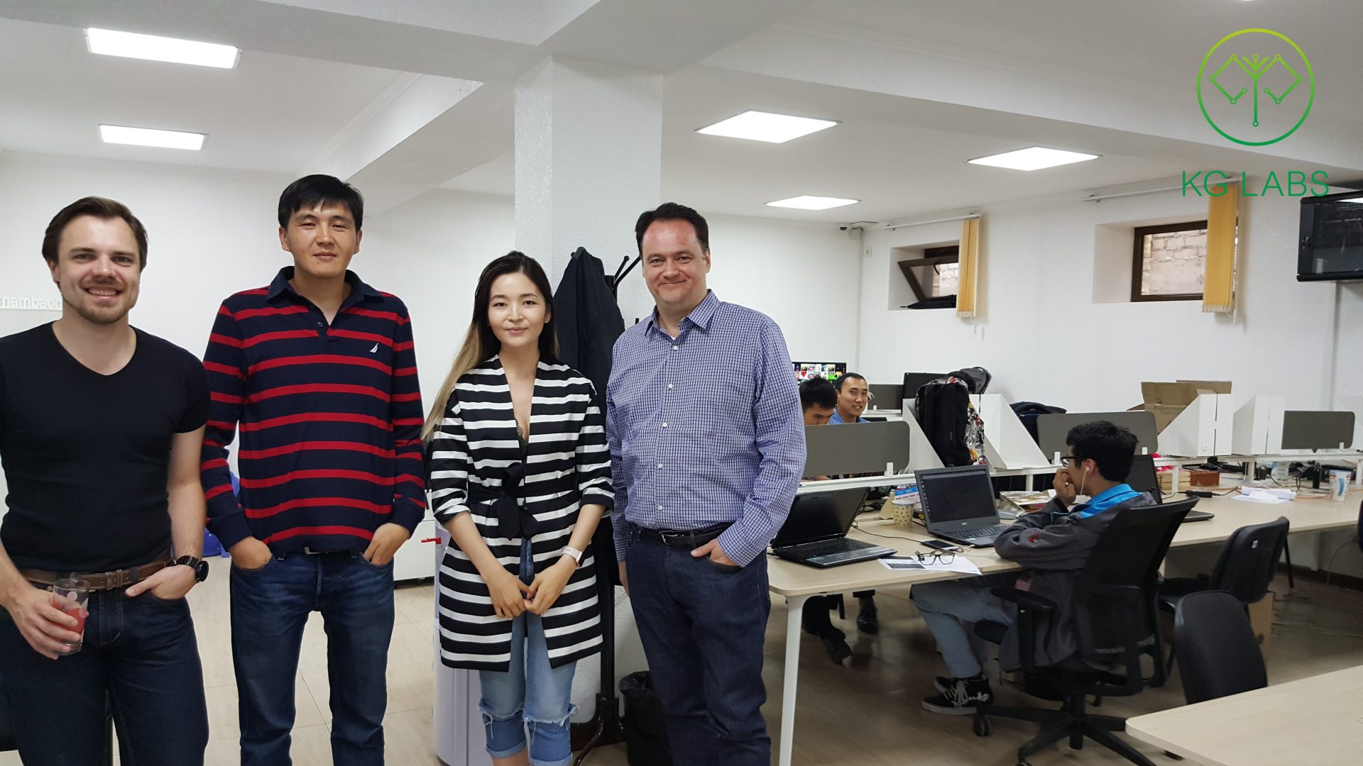 Four individuals posing for a photo in an office setting.