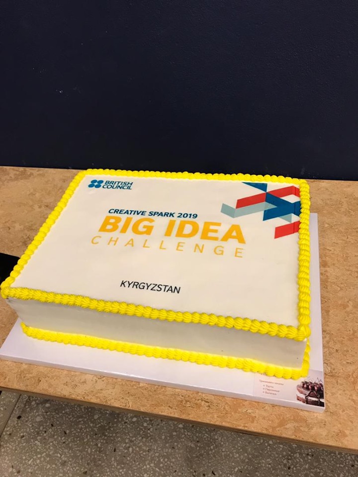 A cake with the text 'Creative Spark 2019 Big Idea Challenge Kyrgyzstan' on it.