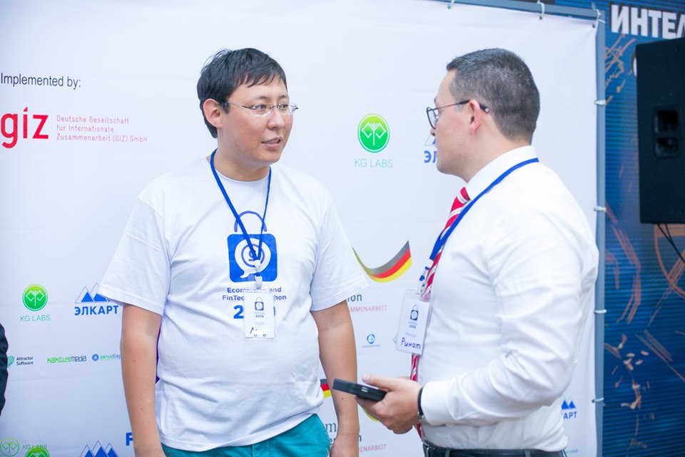 Two individuals engaged in conversation at an event organized by KG Labs in Bishkek, Kyrgyzstan.