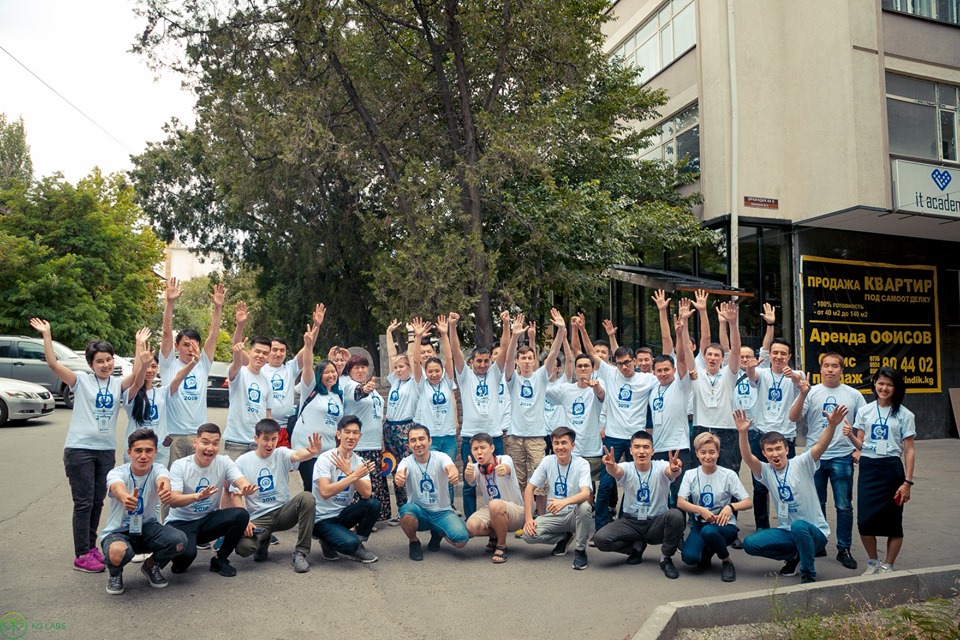 A large group of people posing for a photo in front of a building.