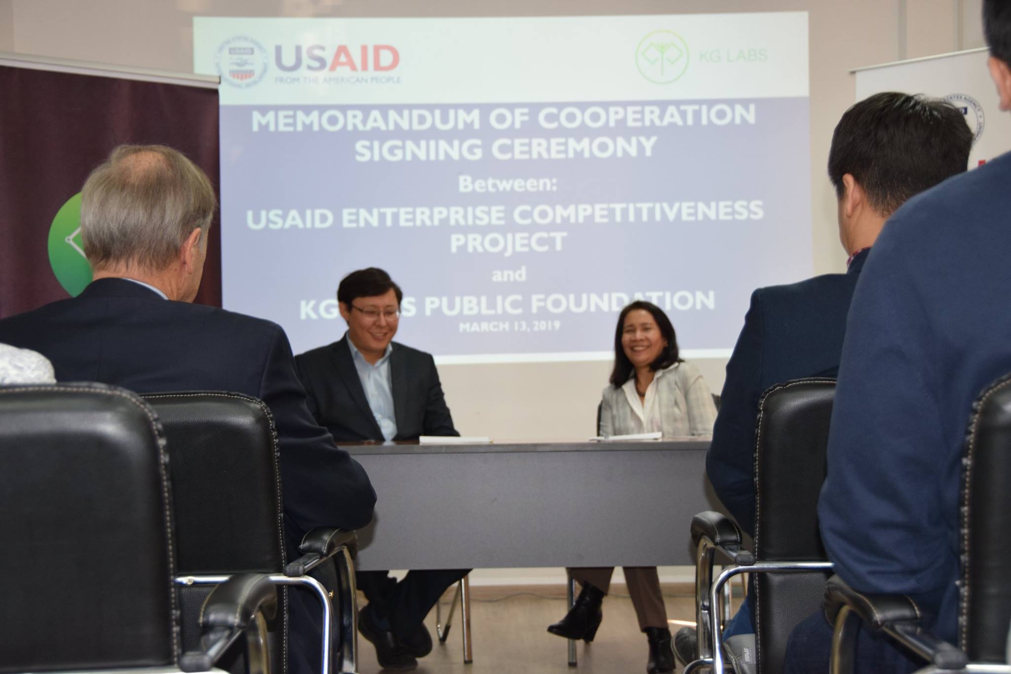 A group of people at a table during a Memorandum of Cooperation signing ceremony between USAID ECP and KG Labs Public Foundation.