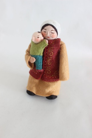 A Craftspring figurine of a Kyrgyz woman in traditional dress carrying a baby — the more recognisably Central Asian end of the same product line. The same hands made both. Source: Craftspring product catalogue, via ITC Ready4Trade research, 2021.